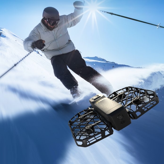 HoverAir X1 Pro Kameradrohne fliegt vor Skifahrer